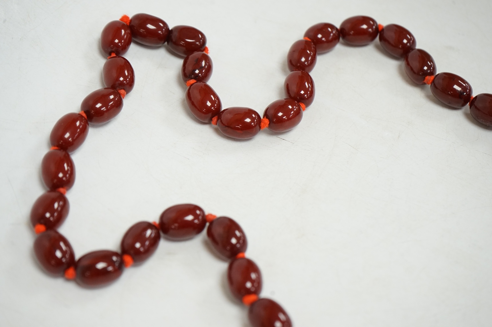 A single strand graduated simulated oval cherry amber bead necklace, 72cm, gross weight 100 grams.